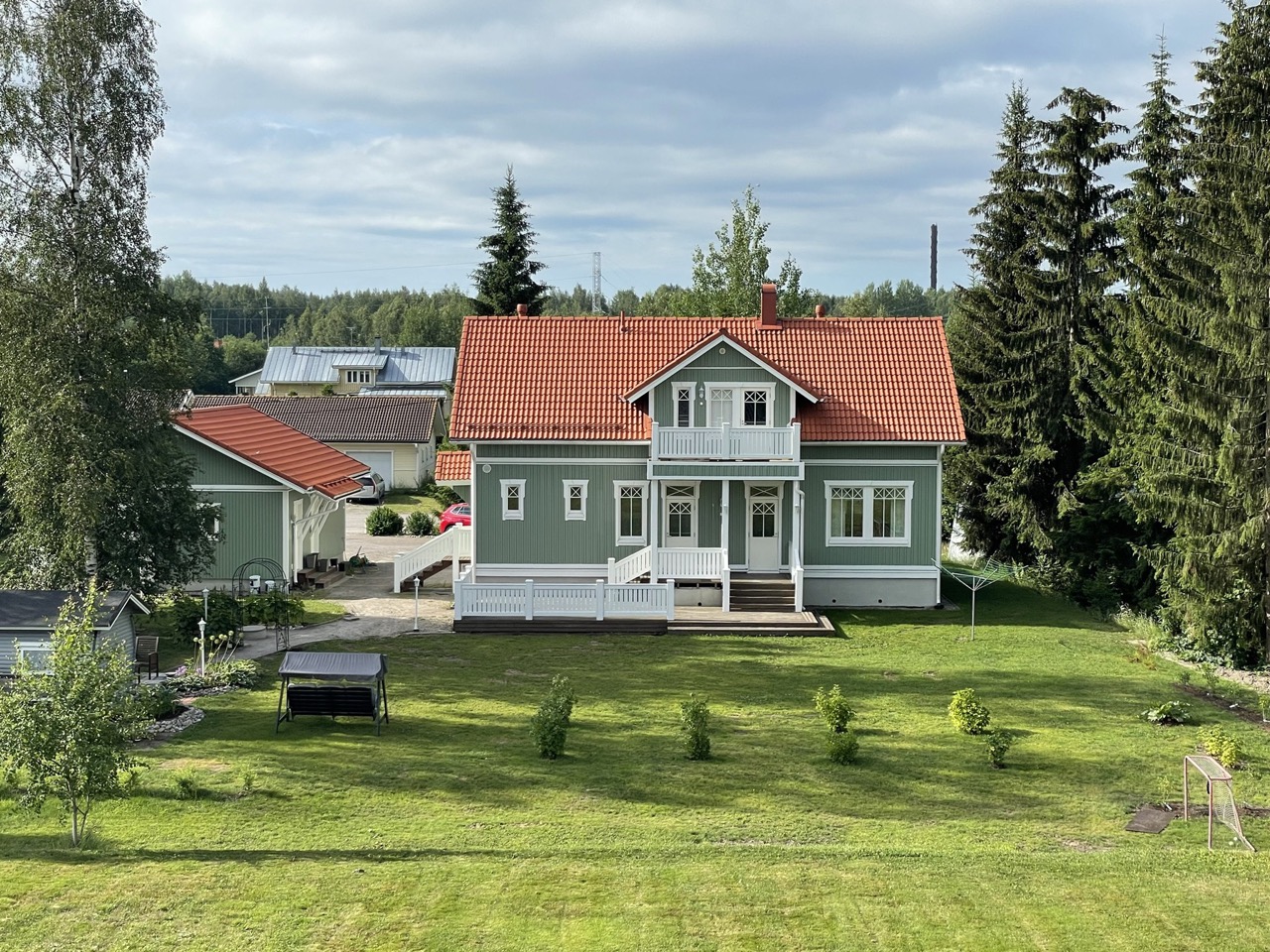 Korkealaatuinen kuva juuri maalatusta omakotitalosta kauniissa pohjoismaisessa maisemassa.