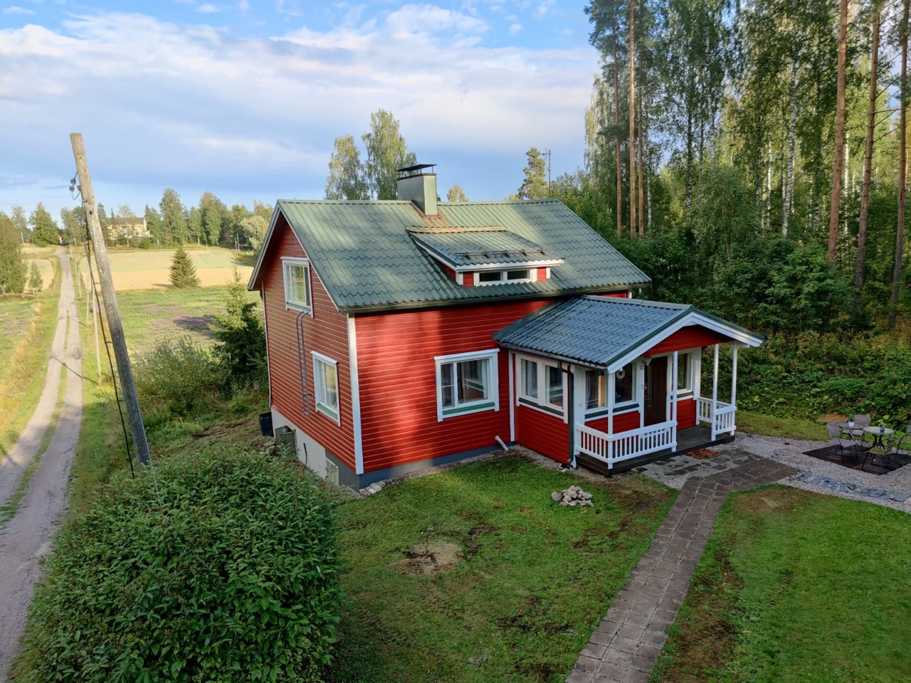 Lähikuva huolellisesti maalatusta tiilikatosta, jossa musta pinnoite kimaltelee auringossa korostaen työn laatua.